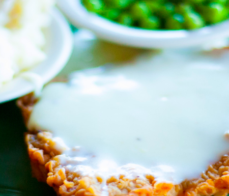 country fried steak, gravy, mashed potatoes, peas